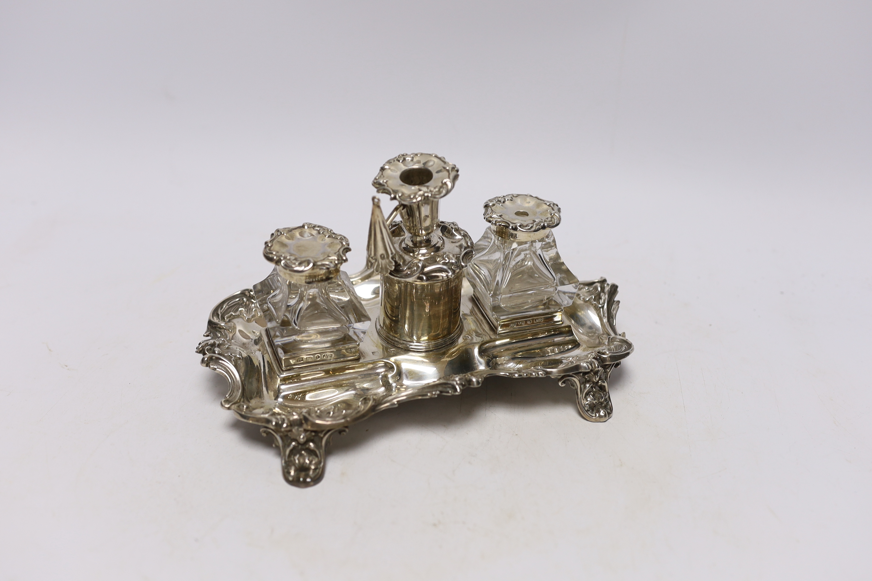 An early Victorian ornate silver inkstand, with two mounted glass wells and central taperstick, Henry Wilkinson & Co, Sheffield, 1844, 21cm